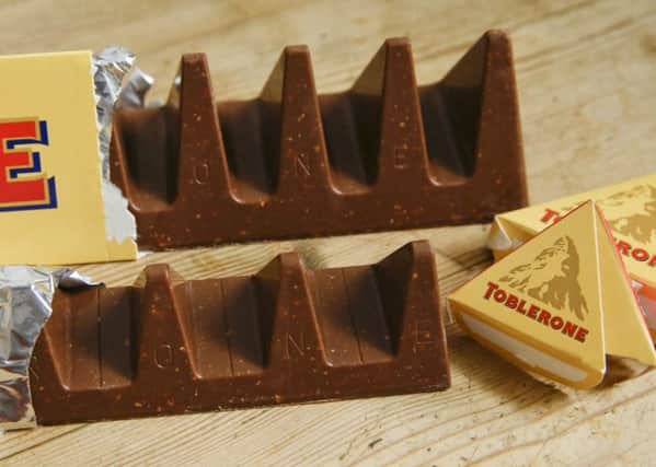 At front is the new style 150 gram bar of Toblerone showing the reduction in triangular pieces, in the background is the older style 360 gram bar. Picture: AP Photo