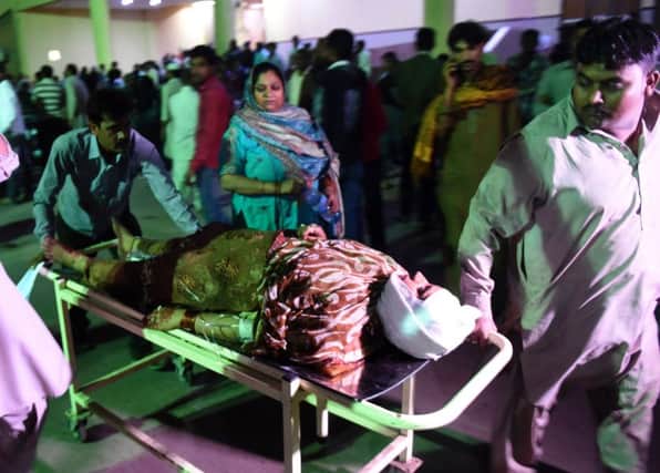 An injured woman is taken to hospital. Photograph: Rizwan Tabassum/Getty