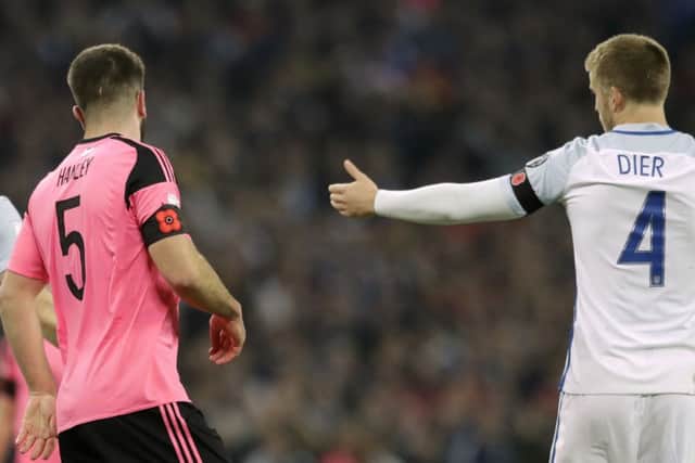 Scotland's Grant Hanley, left, and England's Eric Dier wear a black armband with a poppy to mark Armistice Day during their World Cup qualifying match. Picture: Matt Dunham/AP