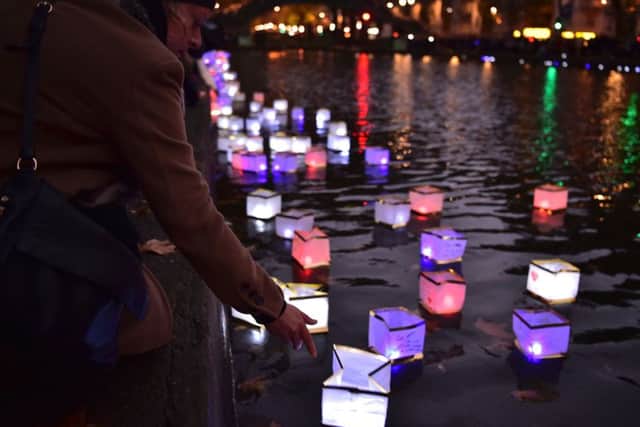 A woman sets afloat a lantern during a lantern ceremony on the Canal Saint-Martin. Picture: AFP/Getty Images