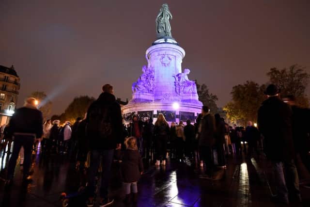 People gather around a makeshit memorial at the bottom of the Marianne statue on place de la Republique. Picture: AFP/Getty Images