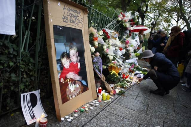 A woman lights candles to pay respect in front of the Bataclan concert hall in Paris. Picture: AP