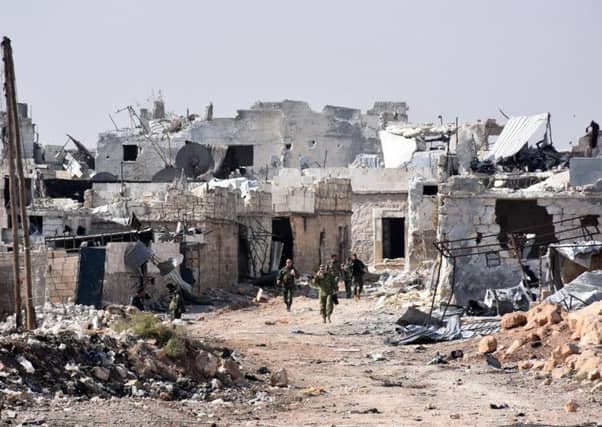 Syrian pro-government forces in the village of Minyan, west of Aleppo, after they retook the area from rebel fighters. Picture: AFP/Getty Images