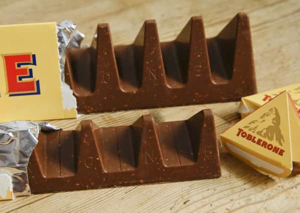 In this photo illustration two bars of the Toblerone Swiss chocolate are shown, at front is the new style 150 gram bar showing the reduction in triangular pieces. (AP Photo/Alastair Grant)