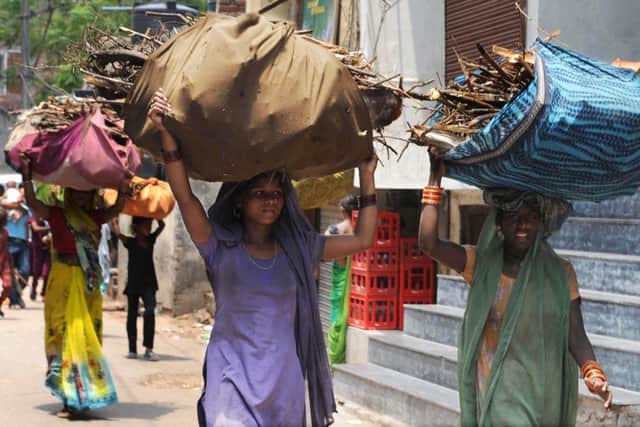 Low-income Indian women carry home branches and twigs to use as fire wood when cooking in Amritsar on July 18, 2009. Cooking without adequate ventilation using biomass materials such as dried cow-dung, fire wood, dry weed or crop residue can worsen tuberculosis and other breathing ailments and is also seen as an environmental threat across Asia. The AFP PHOTO/NARINDER NANU (Photo credit should read NARINDER NANU/AFP/Getty Images)