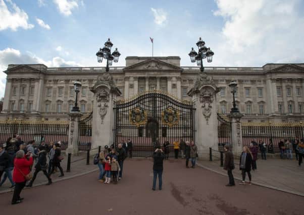 Tourists take pictures outside Buckingham Palace in central London. Officials have said that the palace is to undergo a major ten year refurbishment, costing more than £360 million. Picture: Getty