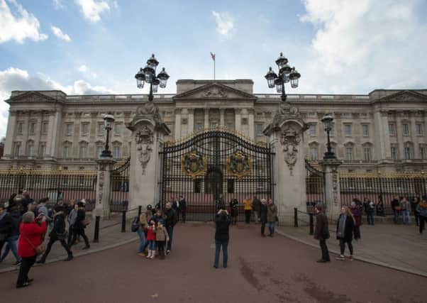 Tourists take pictures outside Buckingham Palace in central London. Officials have said that the palace is to undergo a major ten year refurbishment, costing more than Â£360 million. Picture: Getty