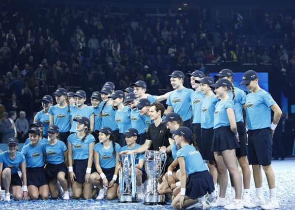 The tournament ball-kids gather round Andy Murray and his two 
trophies  one for winning the World Tour Finals and the other for finishing 2016 No 1 in the rankings.