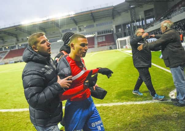 Jordan Larsson, centre, son of former Celtic star Henrik Larsson, is escorted from the pitch after being confronted by fans. Picture: AP