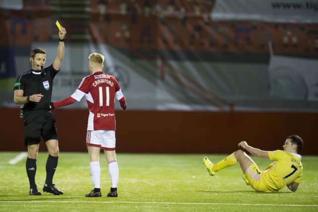 Ali Crawford was booked for the tackle on Jamie Walker, right. Picture: SNS