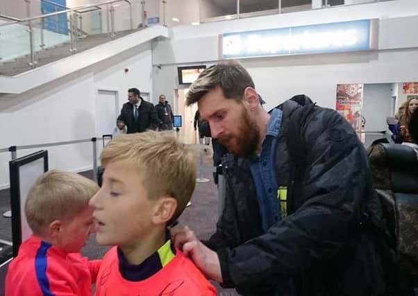 Lionel Messi signs Callum's shirt at Prestwick Airport. Picture: SWNS
