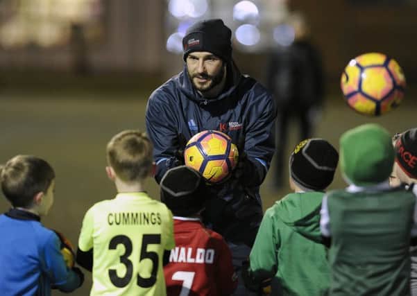 Kevin Thomson coaches kids at his new soccer school. 
Picture: Neil Hanna