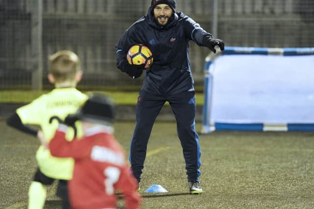 Kevin Thomson coaches kids at his new football academy at Oxgangs Primary School in Edinburgh. Picture: Neil Hanna