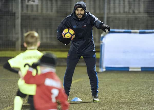 Kevin Thomson coaches kids at his new football academy at Oxgangs Primary School in Edinburgh. Picture: Neil Hanna