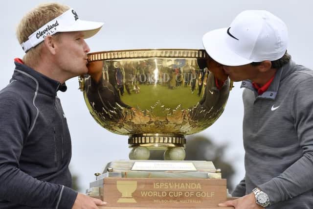 Denmark's Soren Kjeldsen, left, and partner Thorbjorn Olesen kiss the trophy after winning the World Cup of Golf at Kingston Heath in Melbourne. Picture: AP Photo/Andrew Brownbill