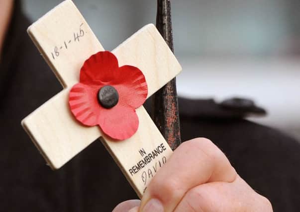 Close up of a man holding a poppy tribute. 
 Picture: Ian Rutherford