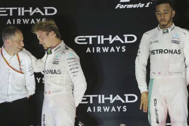 Nico Rosberg, left, celebrates as his despondent team-mate Lewis Hamilton looks on. Picture: Kamran Jebreili/AP