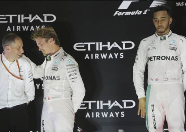 Nico Rosberg, left, celebrates as his despondent team-mate Lewis Hamilton looks on. Picture: Kamran Jebreili/AP