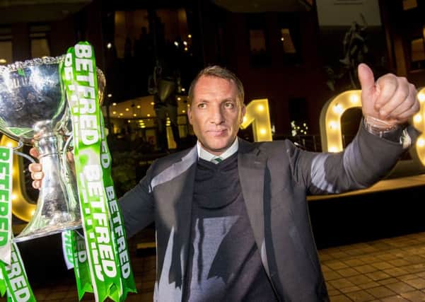 Brendan Rodgers holds aloft the Betfred Cup outside Celtic Park. Pic: SNS