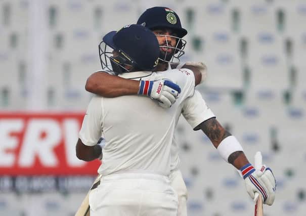 Captain Virat Kohli, right, and Parthiv Patel embrace each other as they celebrate India's win over England on the fourth day of the third Test in Mohali. Picture: AP Photo/Altaf Qadri