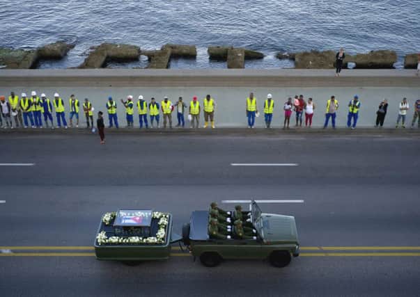 Mourners line the streets of Cuba as the motorcade passes carrying the ashes of Fidel Castro to their final resting place in Santiago. Picture: AP