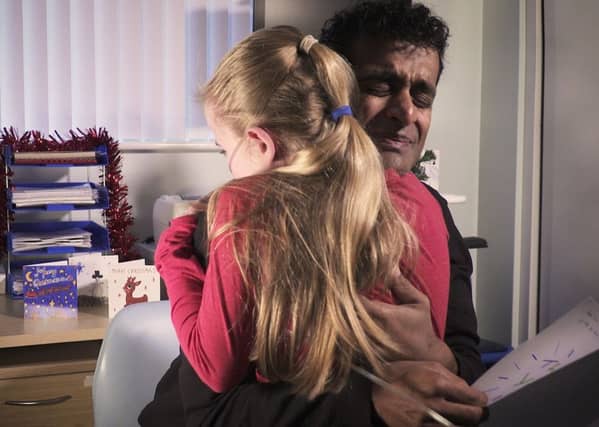 Dr Ravi Jayaram hugs Elle Grace Morris after reading her thank you letter. Picture: Cystic Fibrosis Trust/Marcel Reinard/PA