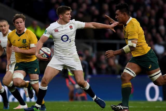 Owen Farrell, of England, fends off a challenge from Australia's Lopeti Timani. Picture: Getty.