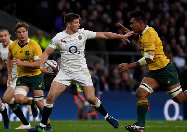 Owen Farrell, of England, fends off a challenge from Australia's Lopeti Timani. Picture: Getty.