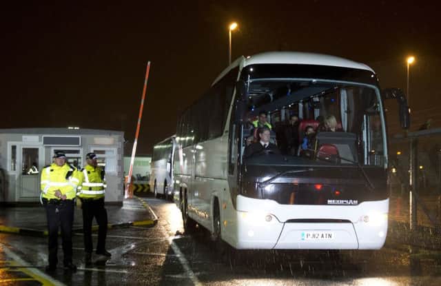 Syrian refugees are driven away in a convoy of buses after landing at Glasgow airport in 2015. Picture: Getty