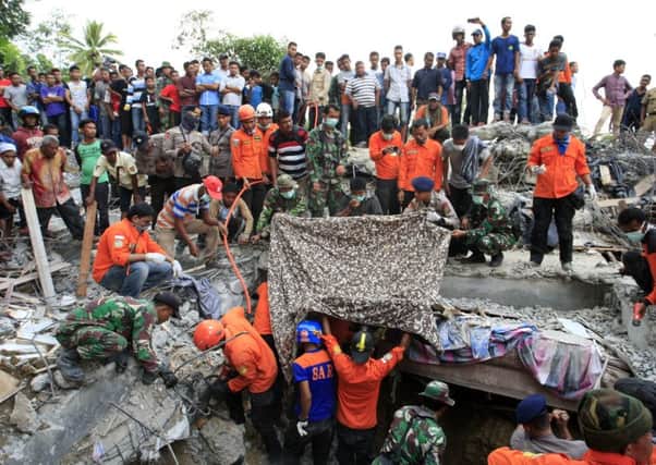 Indonesian soldiers and a search and rescue team look for survivors amongst the rubble  yesterday in Lueng Putu town, Aceh province. Picture: Getty Images