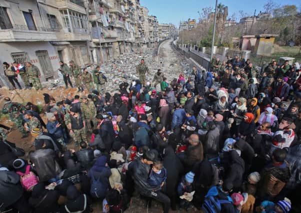 Residents fleeing the violence in Aleppo gather at a checkpoint in Maysaloun neighbourhood. Picture: Getty