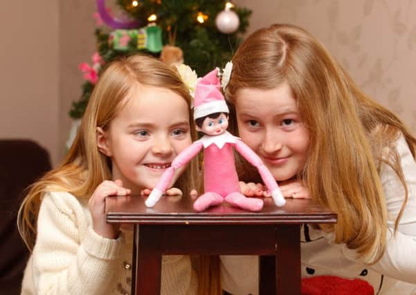 Sisters Rose and Ruby Donaldson with their Elf On The Shelf, named Ella. Photograph: Scott Louden