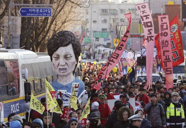 Protesters carry an effigy of impeached South Korean President Park Geun-hye as they march toward the presidential house during a rally in Seoul Saturday, Picture; AP