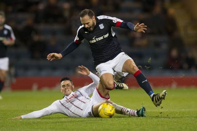 Dundee's Tom Hateley (right) battles for the ball against Ross County's Tim Chow. Picture: SNS
