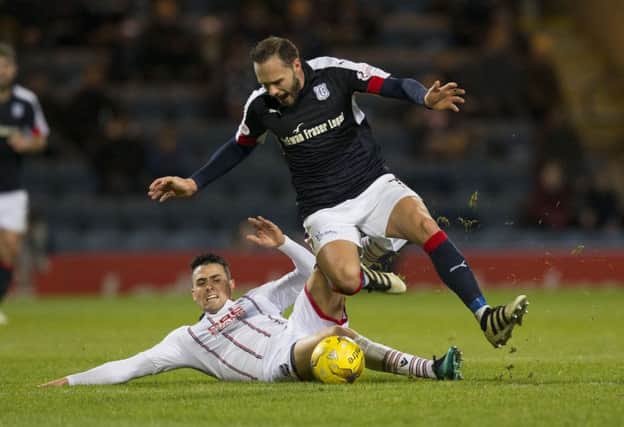 Dundee's Tom Hateley (right) battles for the ball against Ross County's Tim Chow. Picture: SNS