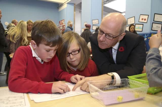 Handout photo issued by the Scottish Government of Education Secretary John Swinney at Towerbank Primary School, Edinburgh, where he launched a scheme of free packs of books and games which are being delivered to all children in primaries two and three by the Scottish Book Trust as part of the Read, Write, Count campaign. PRESS ASSOCIATION Photo. Picture date: Thursday November 10, 2016. The bundles are said to have been designed to provide a fun learning experience for youngsters at school and home, with experts hoping they will encourage parents to engage actively in their child's learning. See PA story SCOTLAND Reading. Photo credit should read: Scottish Government/PA Wire

NOTE TO EDITORS: This handout photo may only be used in for editorial reporting purposes for the contemporaneous illustration of events, things or the people in the image or facts mentioned in the caption. Reuse of the picture may require further permission from the copyright holder.