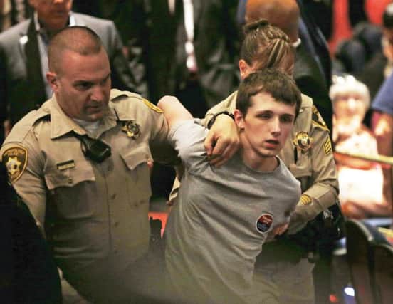 Police remove Michael Steven Sandford at the rally. Picture: AP Photo/John Locher