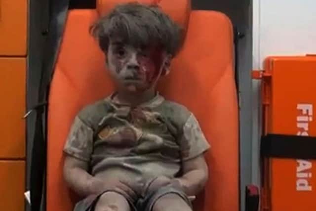 Omran, a four-year-old Syrian boy covered in dust and blood, in an ambulance after being rescued from the rubble of a building hit by an air strike in  Aleppo. Picture: Getty Images