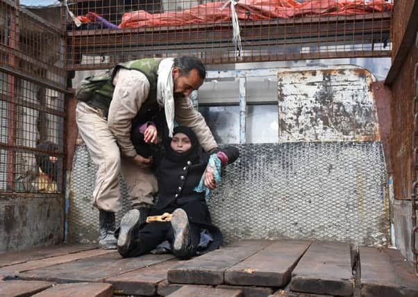 A woman is helped on to the back of a truck after being injured in an airstrike