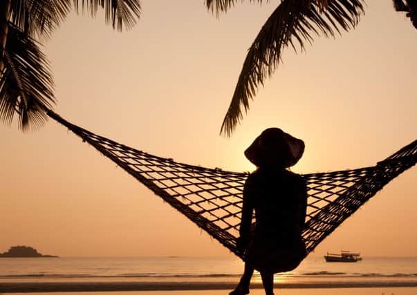 woman in hammock enjoying sunset on the beach