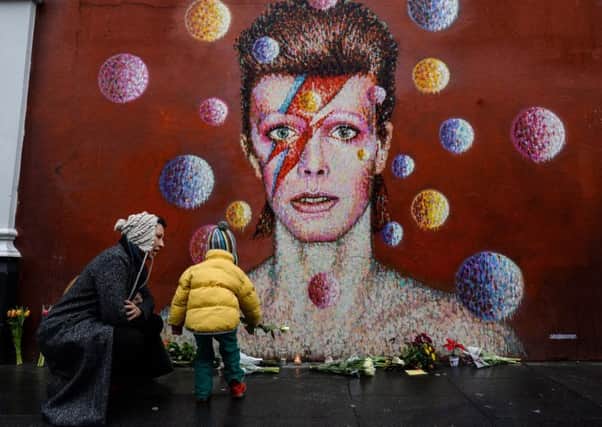 Floral tributes are laid at a mural of David Bowie by Australian street artist Jimmy C in Brixton, south London. Picture: Chris Ratcliffe/Getty