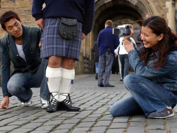 Chinese tourists Shimy Fangfang and John Zuoming admire a Castle guard's kilt.