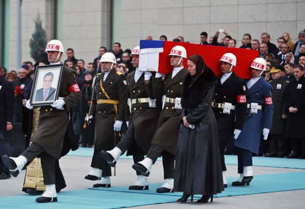 Marina Karlov mourns her husband by laying her head on top of a flag-wrapped coffin of late Russian Ambassador to Turkey Andrei Karlov before being carried to a plane by Turkish soldiers. Picture: Erhan Ortac/Getty Images