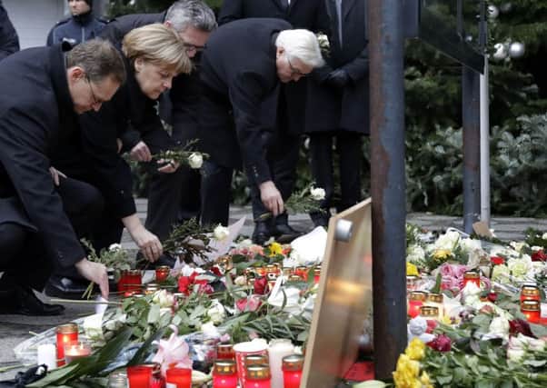 From left, the Mayor of Berlin Michael Mueller, German Chancellor Angela Merkel, German Interior Minister Thomas de Maiziere and German Foreign Minister Frank-Walter Steinmeier attend a flower ceremony at the Kaiser-Wilhelm-Gedaechniskirche in Berlin - the day after a truck ran into a crowded Christmas market and killed several people. Picture: AP Photo/Michael Sohn