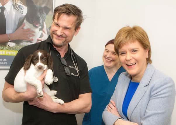 First Minister Nicola Sturgeon celebrates opening the new Glasgow Scottish SPCA centre with vet Ian Futter and senior nurse Sarah Milne.
 Picture: Peter Devlin
