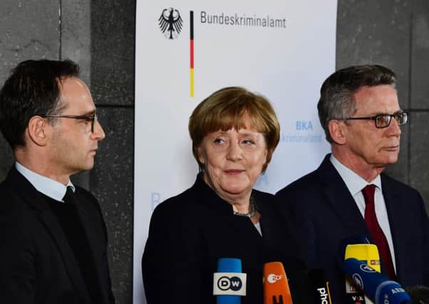 Angela Merkel delivers a statement flanked by Justice Minister Heiko Maas (left) and Interior Minister Thomas de Maiziere. Picture: AFP/Getty Images