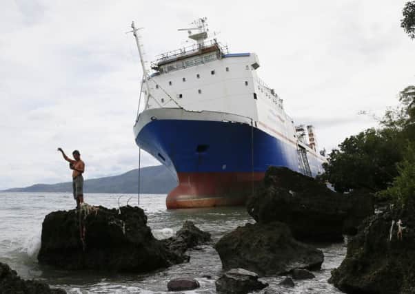 A passenger ferry rests by the shore after being swept off course by typhoon Nock-Ten off Batangas province south of Manila. Picture: AP