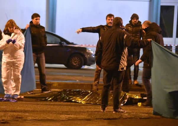A body is covered in a thermical blanket as Italian police cordon off an area after a shootout between police and a man in Milan's Sesto San Giovanni neighborhood. (AP Photo/Daniele Bennati)