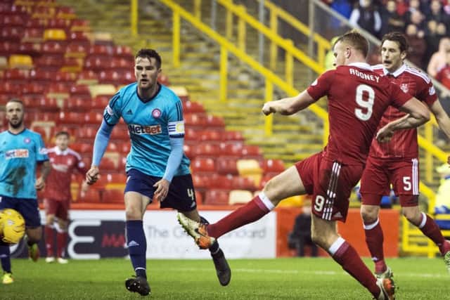 Adam Rooney sweeps home the winning goal. Picture: Ross Parker/SNS