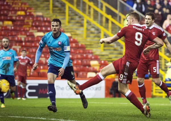Adam Rooney sweeps home the winning goal. Picture: Ross Parker/SNS